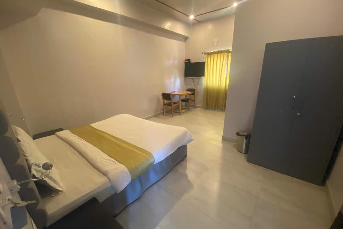 Una habitación de hotel con cama, escritorio y silla.