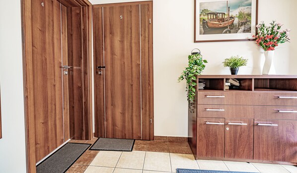 A wooden wardrobe with multiple drawers and a small plant on top. - Hotelik Przy Promenadzie (Swinoujscie)