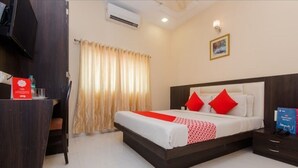 A hotel room with a bed, a desk, and a chair. - Hotel Venture Grand (Mumbai)