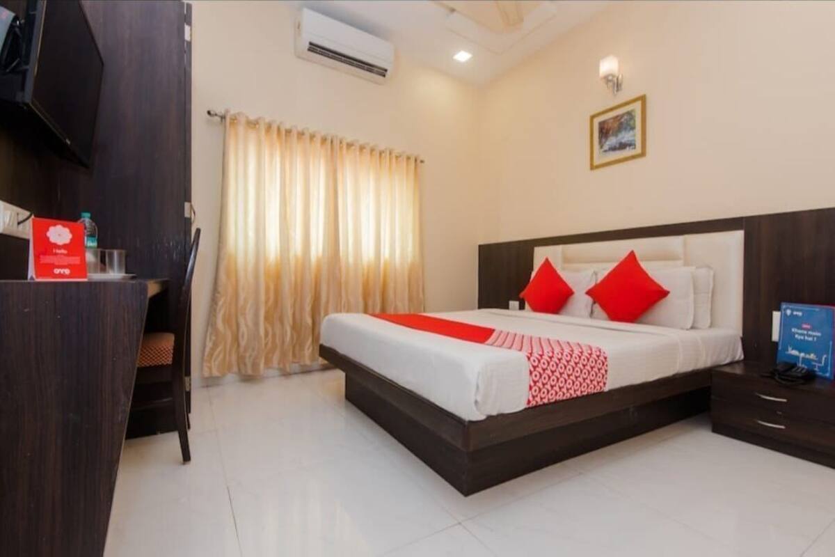 A hotel room with a bed, a desk, and a chair.