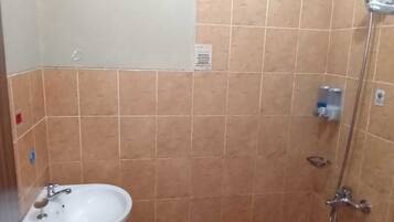 A bathroom with a sink, a shower, and a toilet.