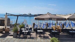 Un bar frente al mar con terraza y vistas al océano.