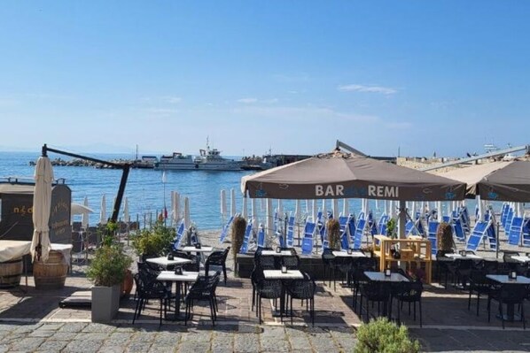 A seaside bar with outdoor seating and a view of the sea. - Ammare House (Cetara)