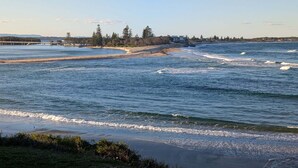 A coastal view with a beach, ocean waves, and a distant bridge. - Amazing Ocean Views, Spacious Waterfront Holiday Apartment (The Entrance)