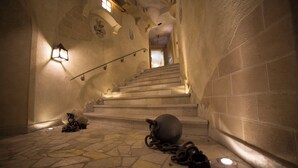 A stone staircase with a large ball and chains on the floor, leading to a door at the top. - Design Chalet Zirm - Check-in at Olympia Hotel (Livinallongo del Col di Lana)