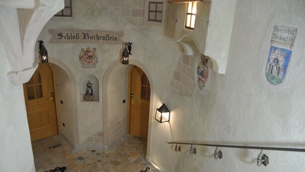 A historic building interior with stone walls, wooden doors, and a staircase. - Design Chalet Zirm - Check-in at Olympia Hotel (Livinallongo del Col di Lana)