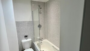 A modern bathroom with a toilet, a bathtub, and a shower enclosure. - Cosy Apartment in the City Centre of Birmingham, walk to everything (Birmingham)