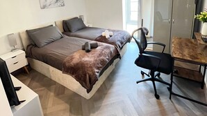 A modern bedroom with two beds, a desk, and a chair. - Cosy Apartment in the City Centre of Birmingham, walk to everything (Birmingham)