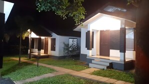 A modern house with a well-lit entrance and a small porch. - Casita Lavender Resort (Vythiri)