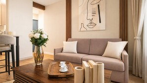 A living room with a sofa, a coffee table, a vase with flowers, and a painting on the wall. - Courtois (Paris)