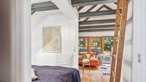 A bedroom with a bed, a map on the wall, and a view of an outdoor seating area.