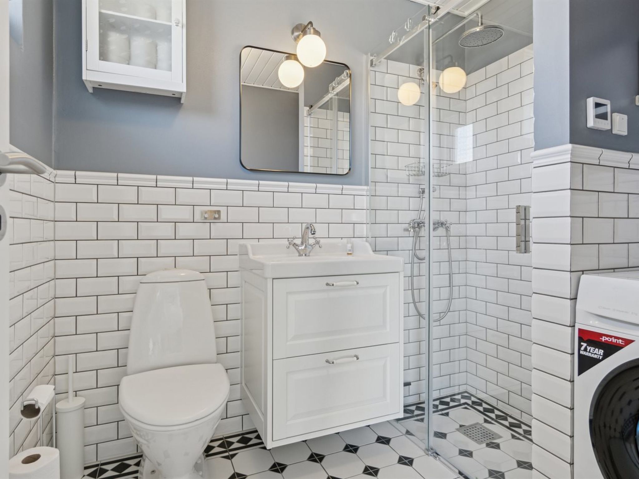 Ein modernes Badezimmer mit Toilette, Waschbecken und Dusche.