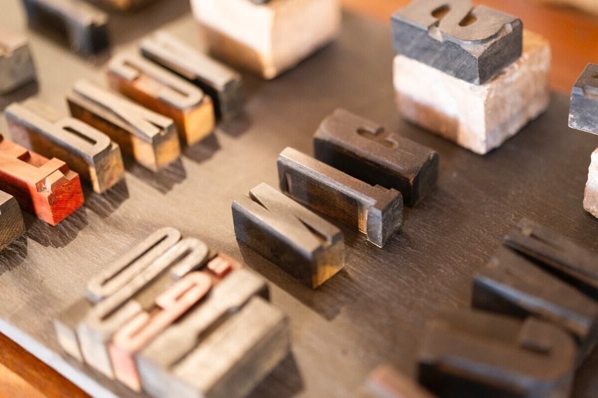 Eine Auswahl aus Metalllettern mit verschiedenen Schriftzügen und Symbolen.