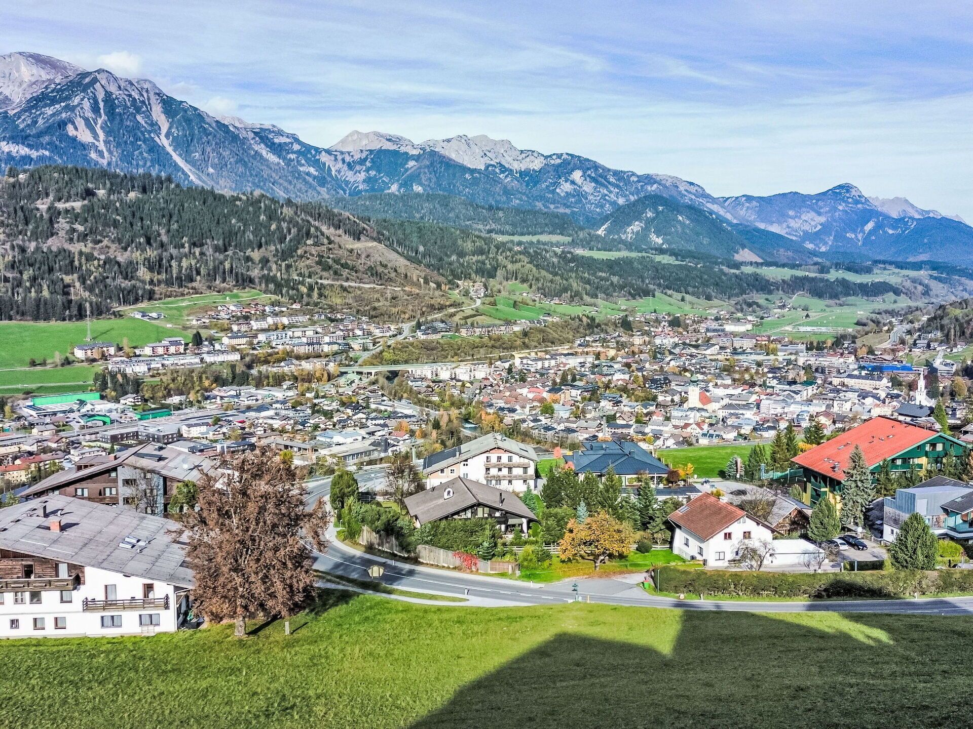 Uma cidade com edifícios residenciais e comerciais, rodeada por montanhas.