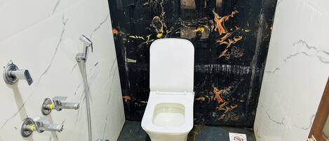Een kleine badkamer met een toilet, een douche en een wastafel.