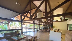 A spacious lobby with high ceilings, a reception desk, and a seating area with sofas and tables. - Malawi Resort (Ipojuca)