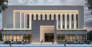 A modern building with a large entrance, multiple windows, and a parking lot with cars. - Regenta Marrievilla Ambala (Ambala)