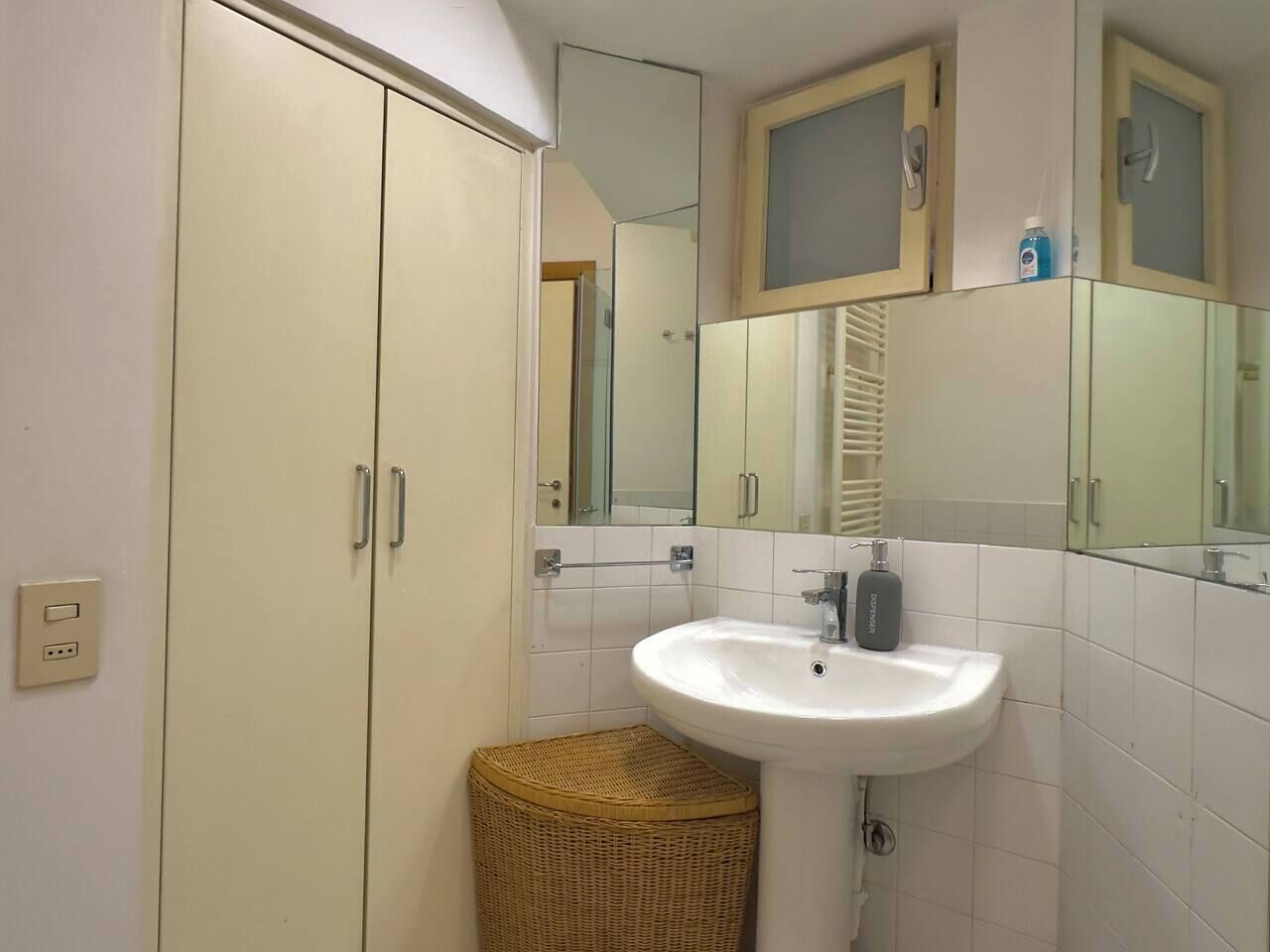A bathroom with a white sink, a mirror, and a cabinet.