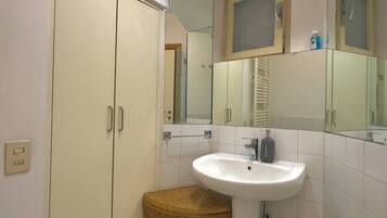 A bathroom with a white sink, a mirror, and a cabinet.