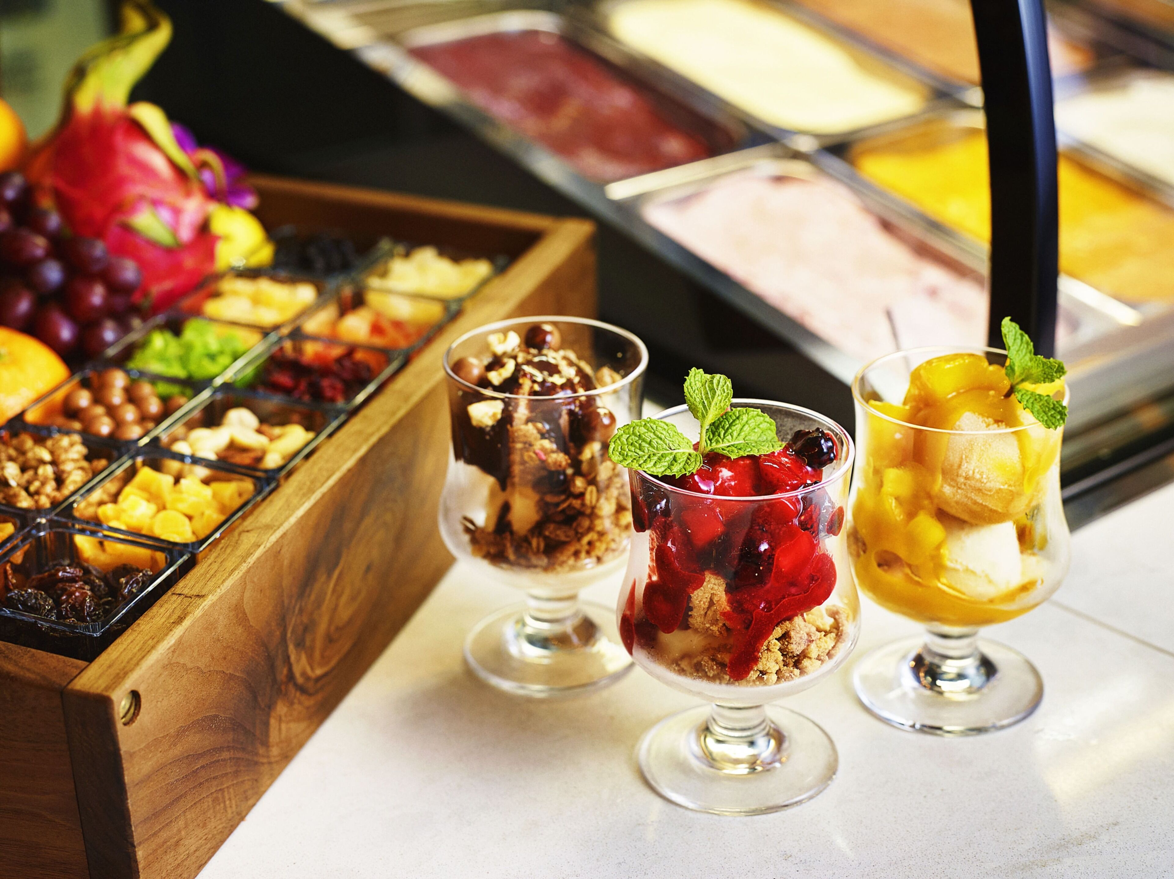 A dessert display with various fruit and nut toppings.