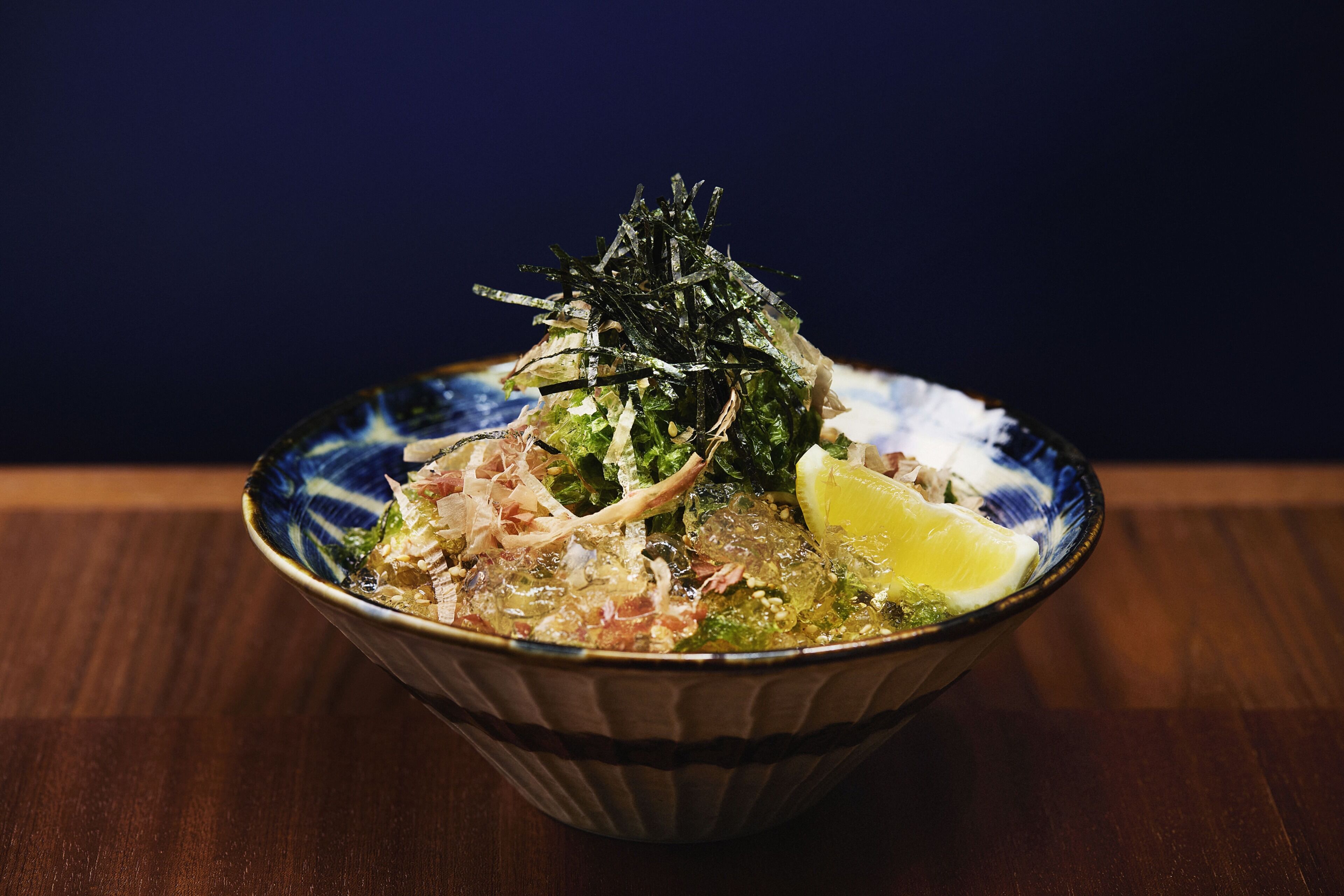 A bowl of food with various ingredients and garnishes.