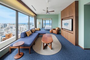 A hotel room with a large window, a bed, a sofa, a table, and a television. - South Gate Hotel Okinawa Naha Tomari Port (Direct Access to Tomarin) (Naha)