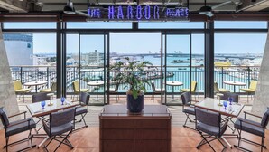 A restaurant with a view of the harbor, featuring a neon sign, outdoor seating, and a potted plant. - South Gate Hotel Okinawa Naha Tomari Port (Direct Access to Tomarin) (Naha)