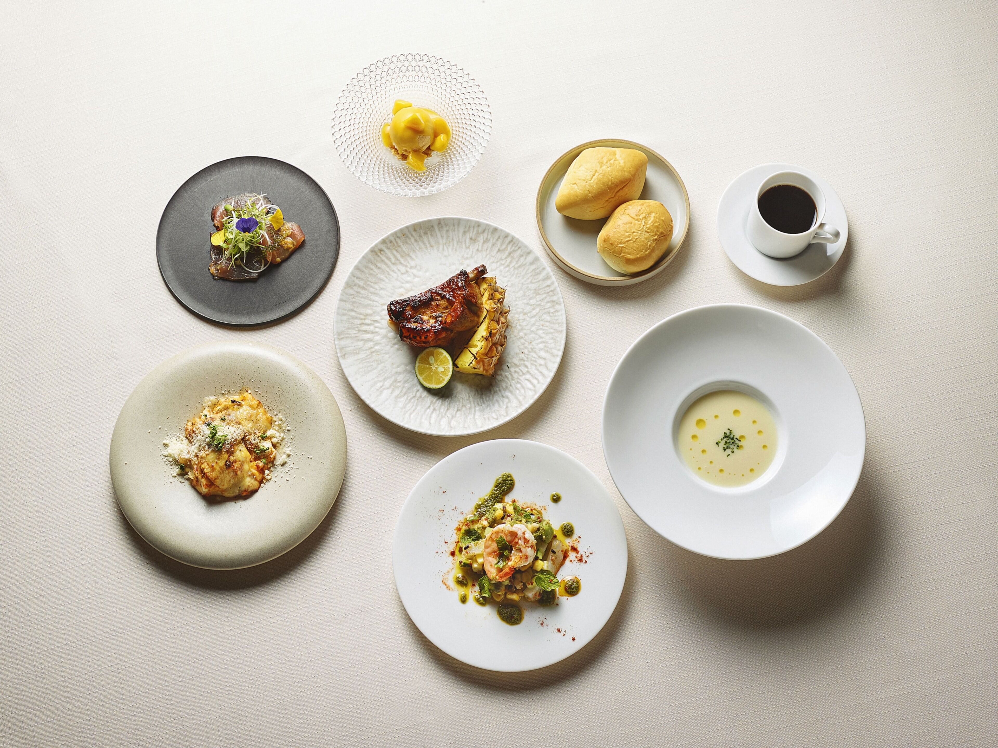Une variété de plats servis dans des assiettes, une tasse de café et un verre d’eau sur une table.