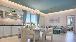 A modern kitchen with a round dining table, two chairs, and a built-in cabinet. - Bougainvillea Bliss (Σκαλα)