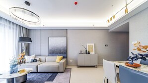 Una sala de estar moderna con un sofá, una mesa de comedor y un cuadro abstracto grande en la pared.