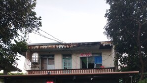 A two-story building with a sign reading "MERRI" and a motorcycle parked in front.