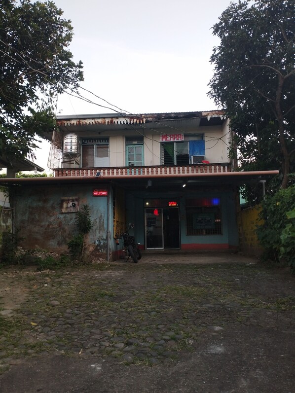 A two-story building with a sign reading "MERRI" and a motorcycle parked in front. - Pri Merra Inn (Pagsanjan)