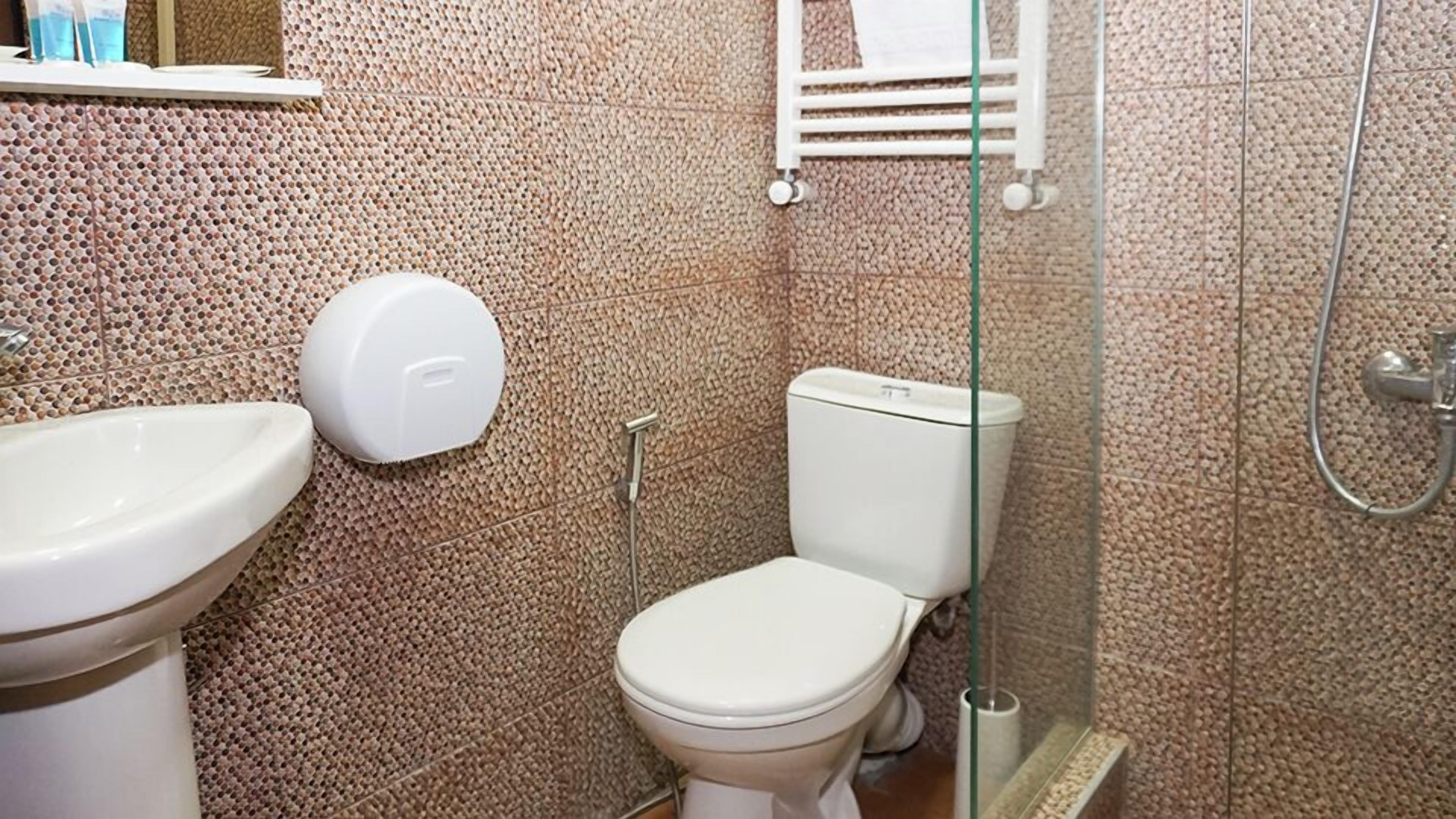 A bathroom with a toilet, bidet, and sink.