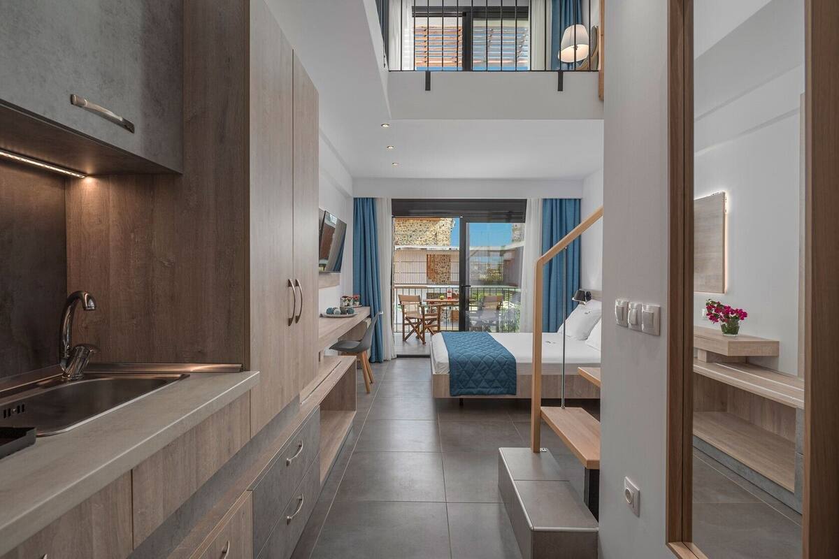 A modern kitchen with a built-in stove, a sink, and a dining area with a table and chairs.
