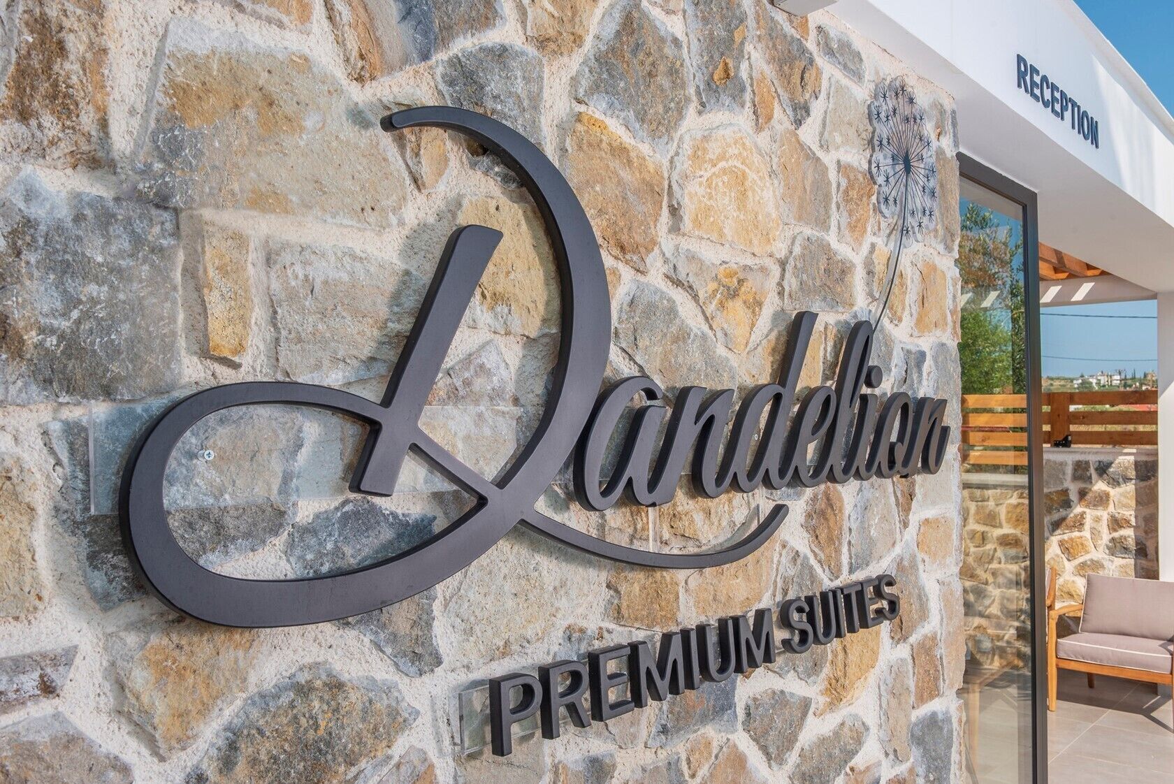 A stone wall with the words "Ladeliha Premium Suites" and a reception sign.