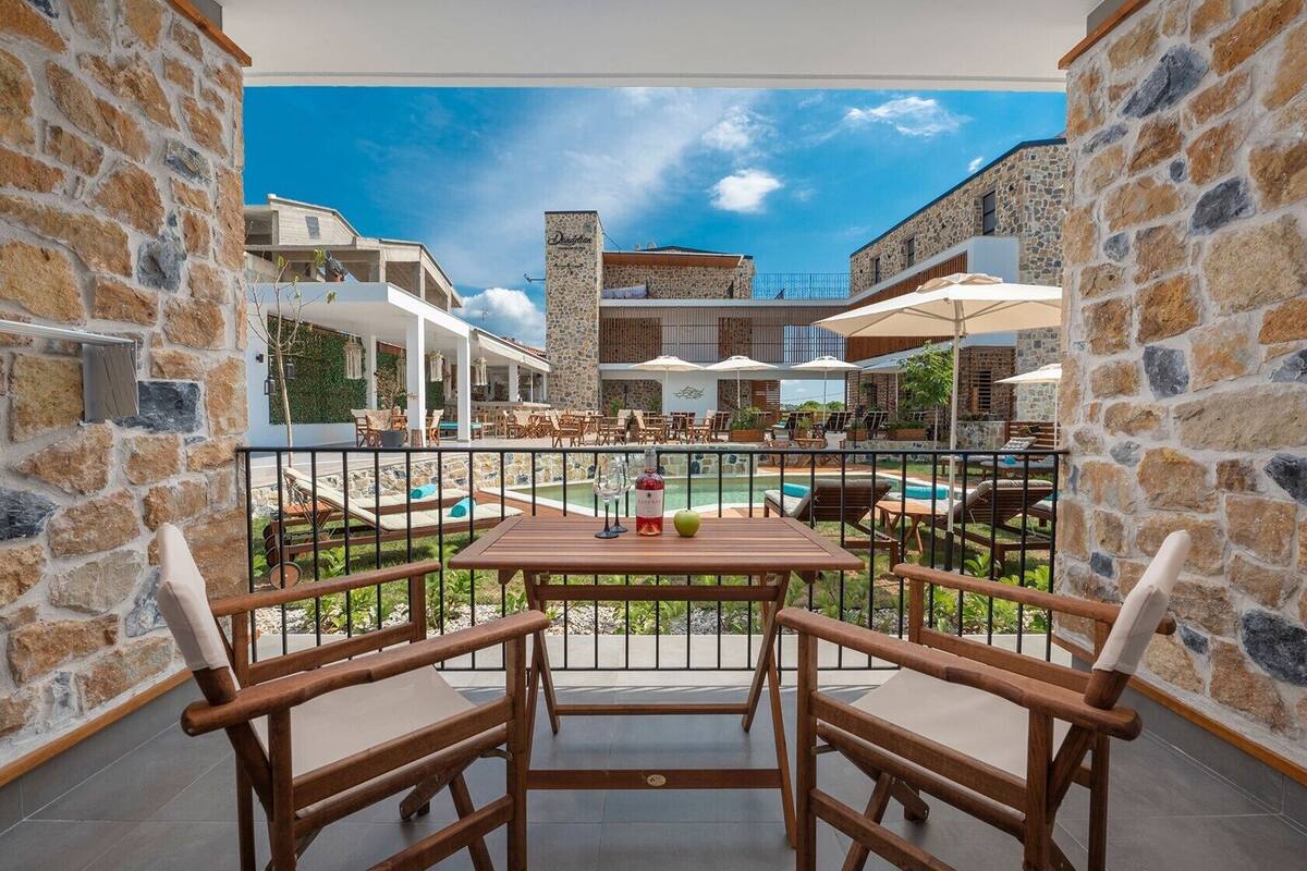 A terrace with stone walls, a pool, and outdoor seating.