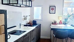 Una cucina moderna con isola centrale, mobili a incasso e una finestra che offre luce naturale.