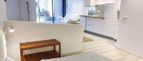 A modern apartment with a kitchen, a dining area, and a balcony.