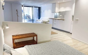 A modern apartment with a kitchen, a dining area, and a balcony.