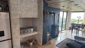 A modern kitchen with a stone backsplash, a built-in stove, and a dining area with a table and chairs.