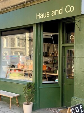 A storefront with a green facade, a sign reading 'Haus and Co', and a visible window display.