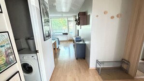 A laundry room with a washing machine, a drying rack, and a small table with a chair. - Cosy and family friendly apartment in Kópavogur - Birta Rentals (Kópavogur)