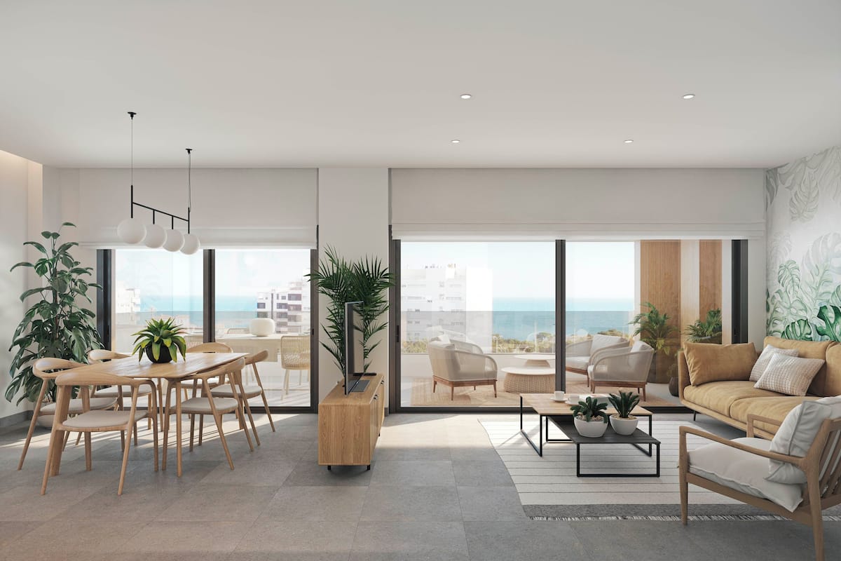 A modern living room with a dining area, large windows, and a view of the ocean.