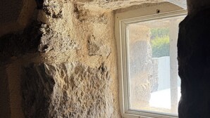 A stone-walled room with a small window.