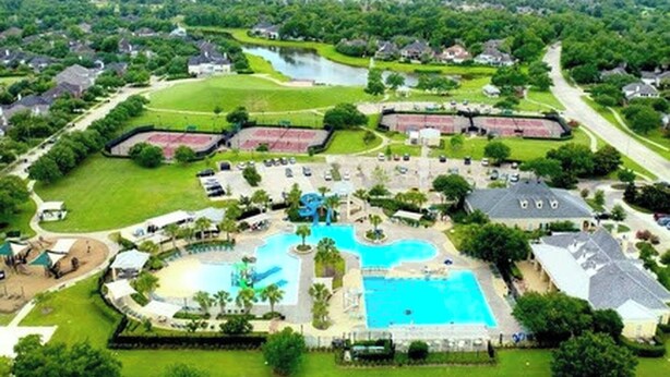 Un gran resort con múltiples piscinas, un campo de golf y un lago.