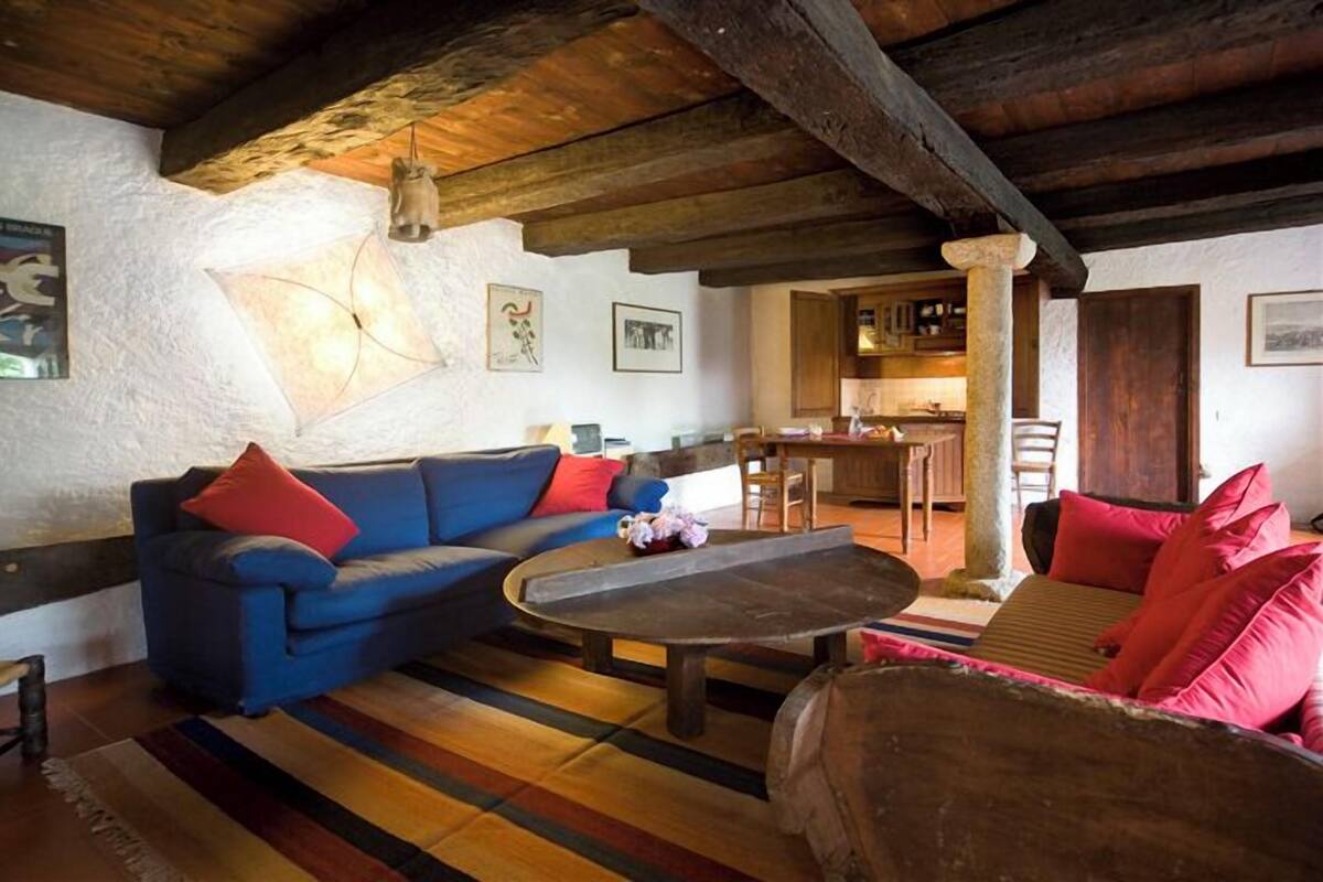 A cozy living room with a blue sofa, a wooden coffee table, and a red couch.
