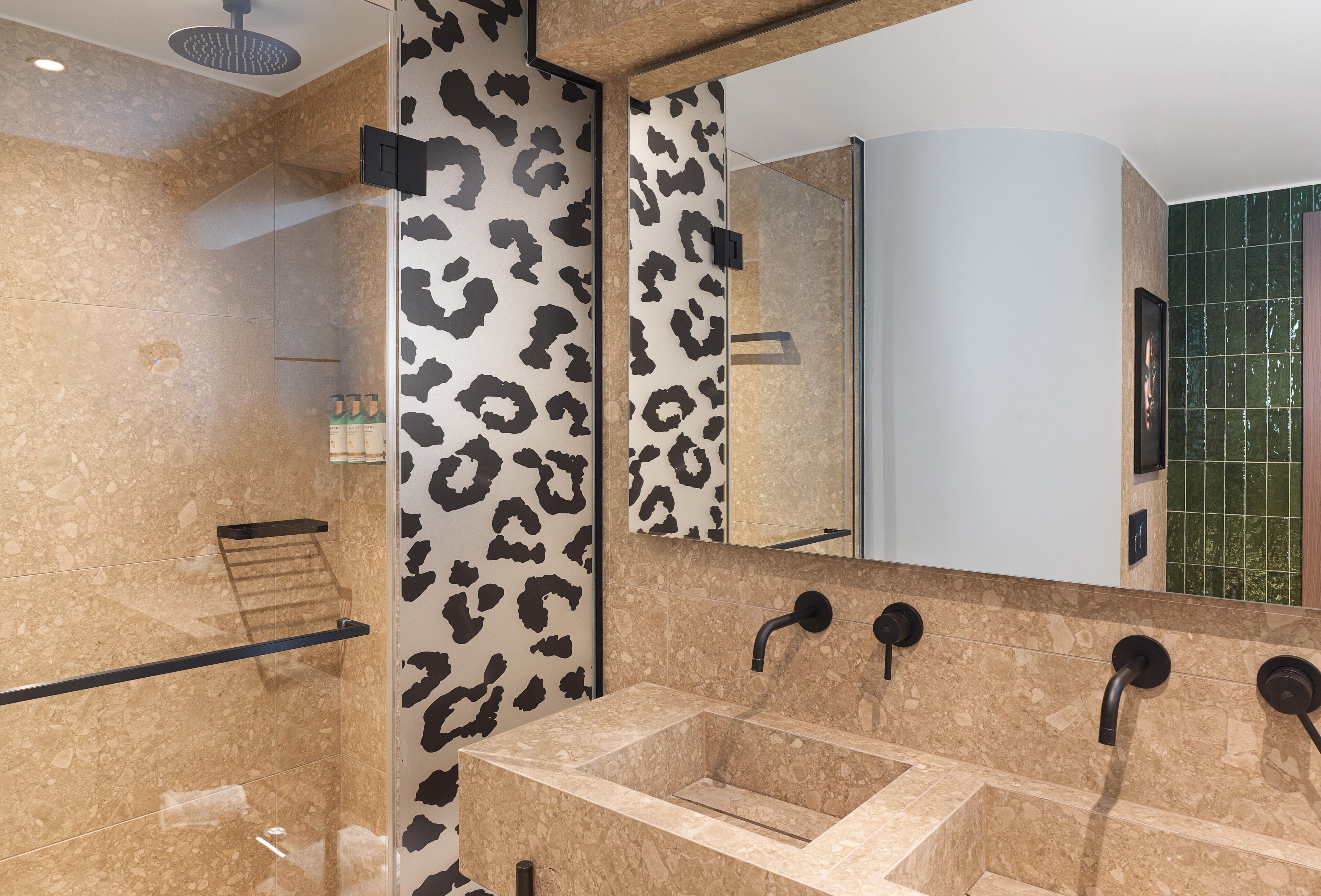 Une salle de bain moderne avec un grand miroir, un meuble-lavabo et un espace douche.
