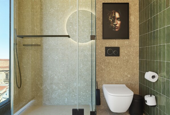 Un baño moderno con cabina de ducha de vidrio, inodoro y dispensador de papel higiénico en la pared.