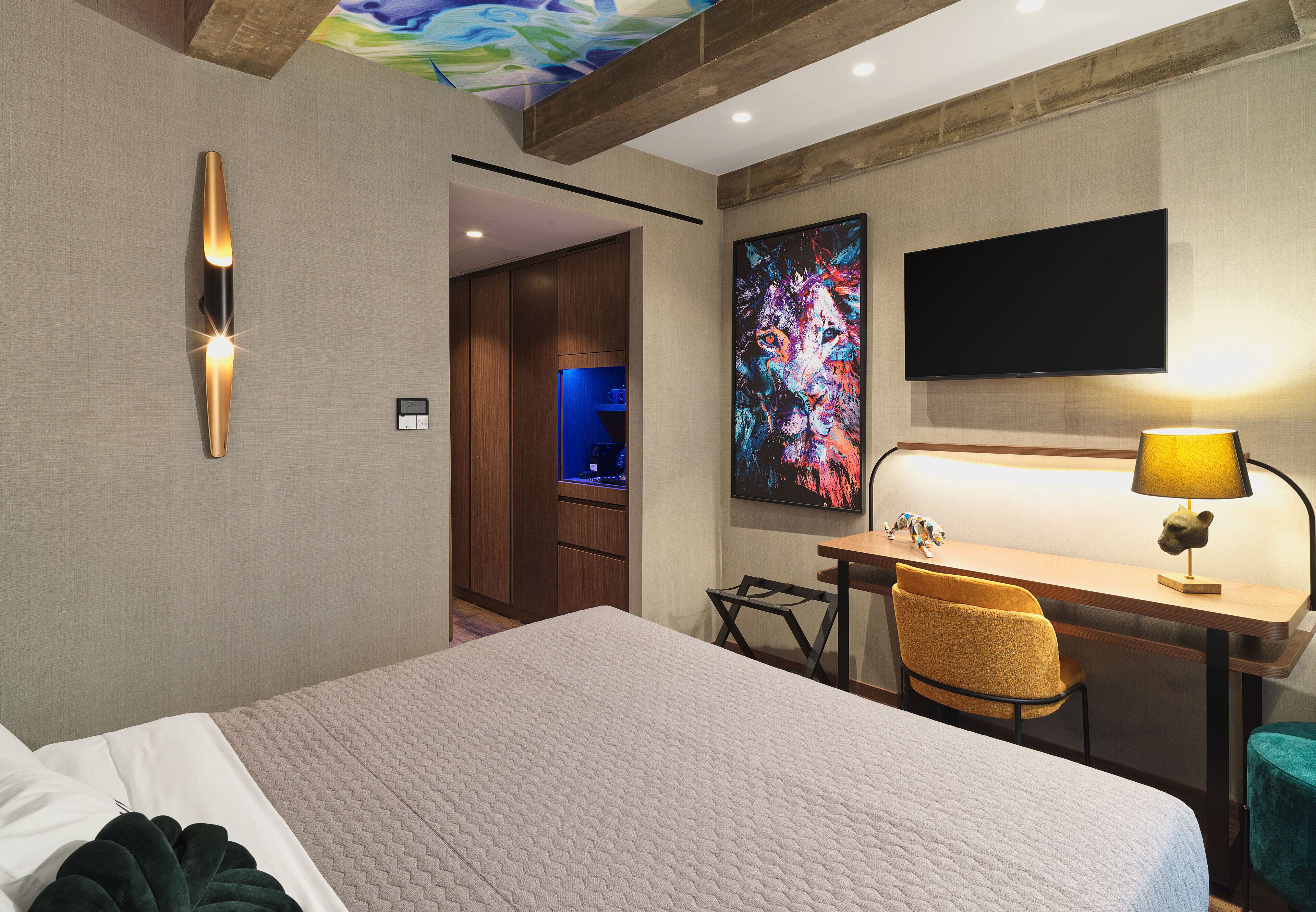 Una habitación de hotel con cama, escritorio, silla y televisión.