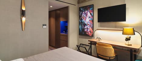 Una habitación de hotel con cama, escritorio, silla y televisión.